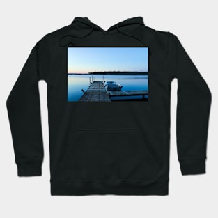 Wooden dock and a boat on blue clear water Hoodie